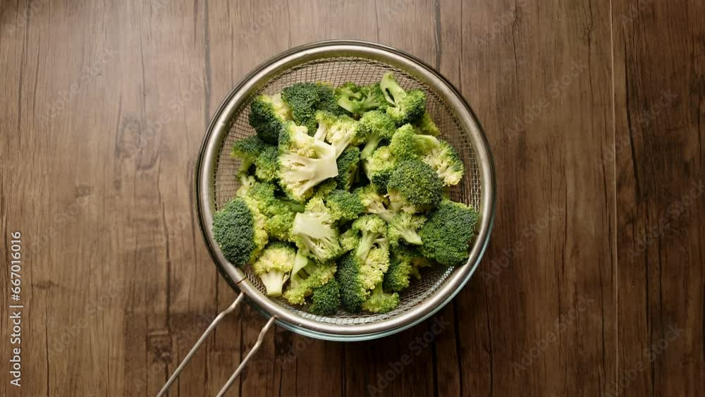 a sieve with cauliflower is placed on a saucepan a sieve with cauliflower is placed on a saucepan