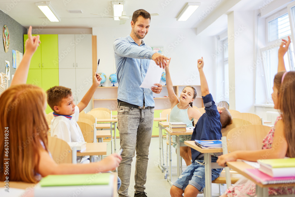 Smiling teacher pointing at girl sitting in classroom Smiling teacher pointing at girl sitting in classroom