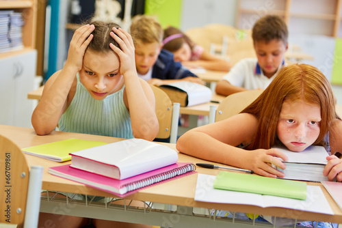 Worried female friends sitting on bench in class photo