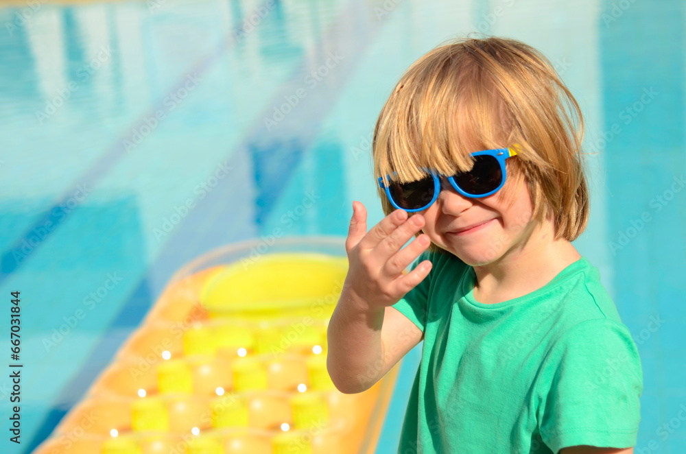 Little boy in a sun lounger at a resort near the pool. Children on vacation, summer days Little boy in a sun lounger at a resort near the pool. Children on vacation, summer days