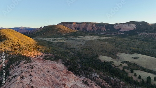 Aerial view of a mountain range in the desert illuminated by the setting sun