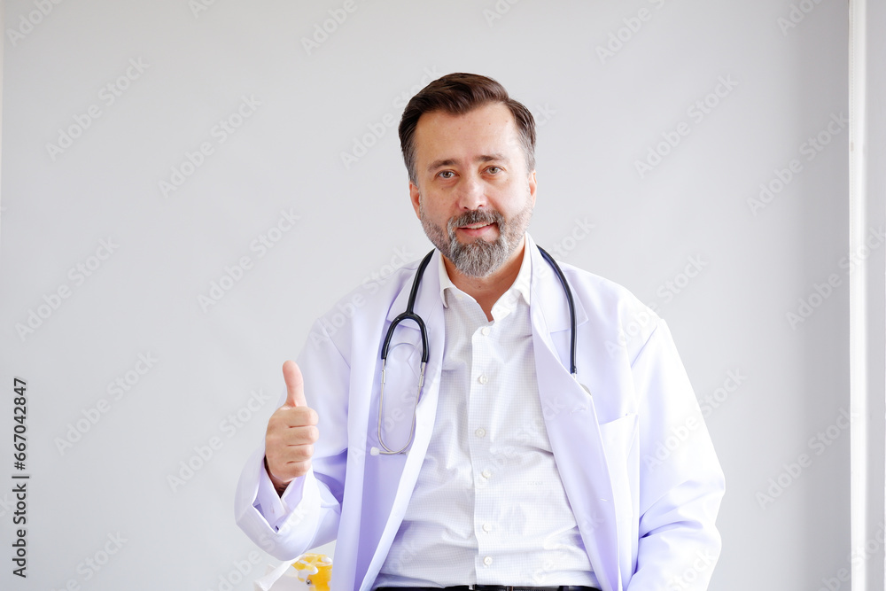 A male doctor wearing a medical uniform stands and smiles. A male doctor wearing a medical uniform stands and smiles.