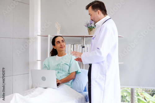Doctor with patient lying on bed in exam room.