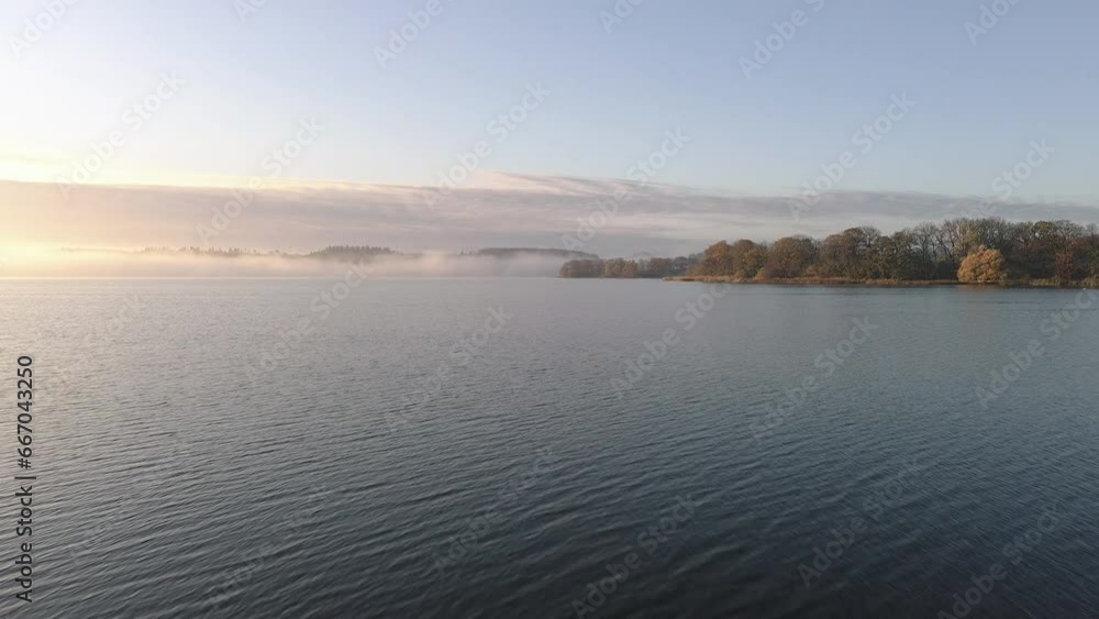 Drone fly overlake early morning with foggy clouds in the background Drone fly overlake early morning with foggy clouds in the background