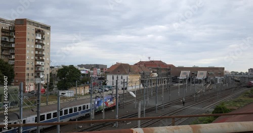 Wallpaper Mural Long passenger train pulling into a railway station. Above viewpoint, cloudy day, city architecture in the background, real time, no people Torontodigital.ca