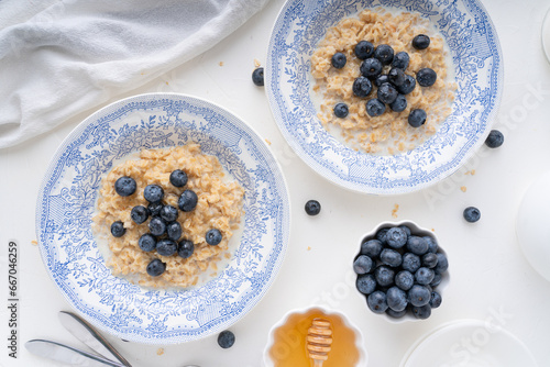 Oatmeal with blueberries for breakfast. Beautiful breakfast setting on a white background. Healthy food with berries.