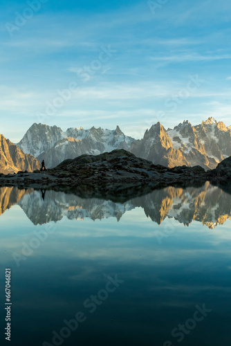 Silhouette of Man, Mountains and Reflection in Lac Blanc Lake at Sunset. Golden Hour. French Alps, France