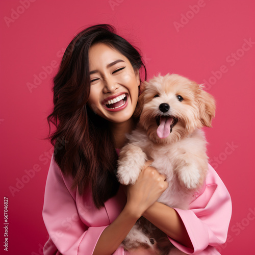 In the photo,an Asian Thai woman radiates pure joy she holds her adorable dog against vibrant pink background.She's dressed in stylish red-pink casual dress,and her laughter is vibrant as her attire.