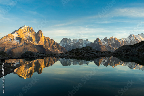 Silhouette of Man, Mountains and Reflection in Lac Blanc Lake at Sunset. Golden Hour. Chamonix, French Alps, France