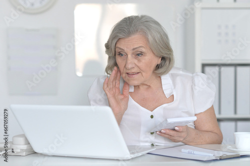 old woman with a laptop on a white background