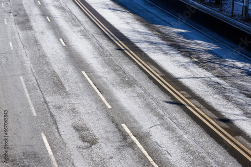 Asphalt road covered with salt stains. Road anti-icing, pre-treatment and de-icing highway in the city in winter season. Salting roads view from above