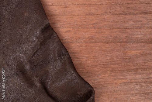 brown genuine leather on stained plywood board, close up