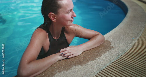 Woman relaxes in the swimming pool. Caucasian brunette girl closeup enjoys holiday vacation on the tropical island hotel resort. Travel  relax  active lifestyle.