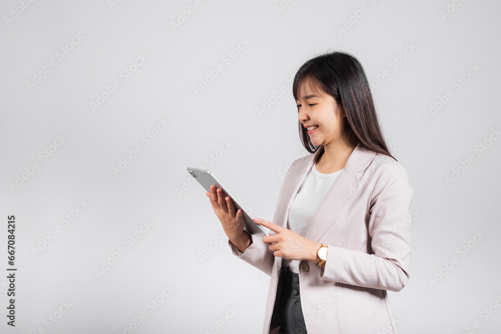 Portrait of Asian beautiful young woman smiling using tablet computer, Happy lifestyle female teen touching screen on digital tablet pc, studio shot isolated on white background Portrait of Asian beautiful young woman smiling using tablet computer, Happy lifestyle female teen touching screen on digital tablet pc, studio shot isolated on white background