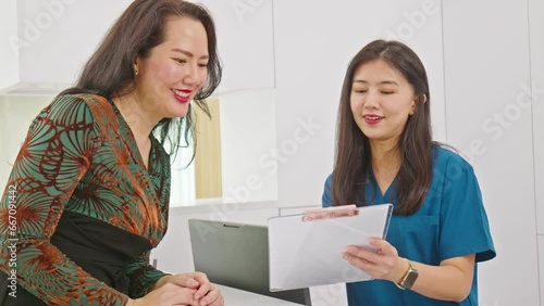 Asian doctor woman talking to patien or customer to check in and check up health course at reception desk or private hospital with service mind.Health care premium service at clinic photo