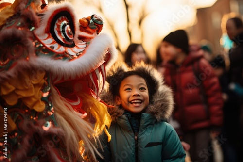 child watching lion dance, wearing a dragon mask and costume eagerly © Daunhijauxx
