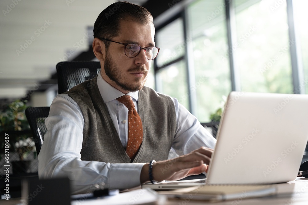 Modern Office Businessman Working on Computer. Portrait of Successful Middle-aged IT Software Engineer Working on Laptop Modern Office Businessman Working on Computer. Portrait of Successful Middle-aged IT Software Engineer Working on Laptop