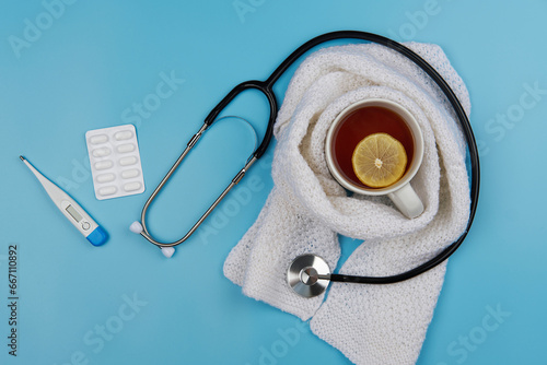 Healthcare, medicine, flu and treatment concept. Tea, stethoscope with thermometer and pills.