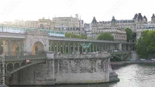 The parisian urban subway (MP 73 metro, metropolitain) passes over a bridge (pont de Bir-Hakeim Passy MP73 line 6) with Haussmann-style buildings in the background in the French capital, Paris, France photo