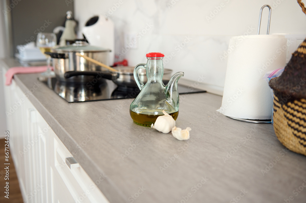 Food still life with a bottle of fresh extra virgin olive oil and garlic cloves on the table at home kitchen countertop Food still life with a bottle of fresh extra virgin olive oil and garlic cloves on the table at home kitchen countertop