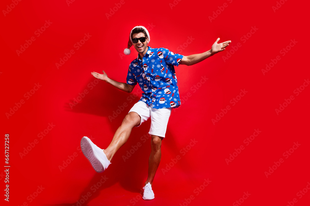 Full length photo of nice young male hands dancing have fun disco wear santa claus print x-mas garment isolated on red color background