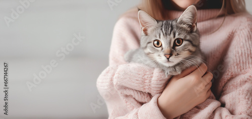 Girl holding little cute kitten. Pet adoption and love to animals concept. banner with place for text