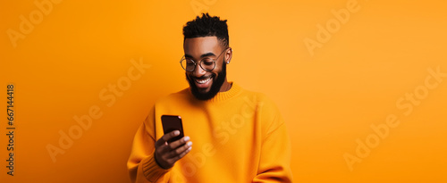 attractive african american man with phone against orange background. halloween,thanksgiving concept etc