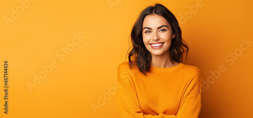 autumn banner with cute smiling model woman against orange background. thanksgiving banner with copy space photo