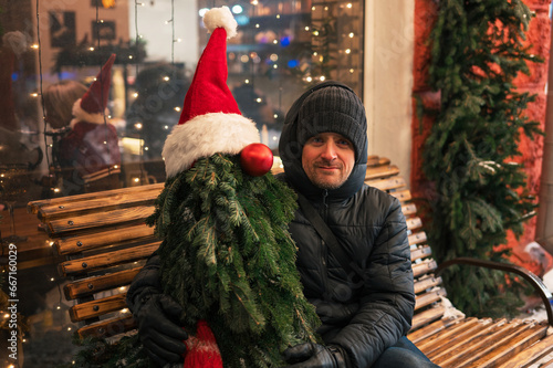 Man with fir tree decorated...