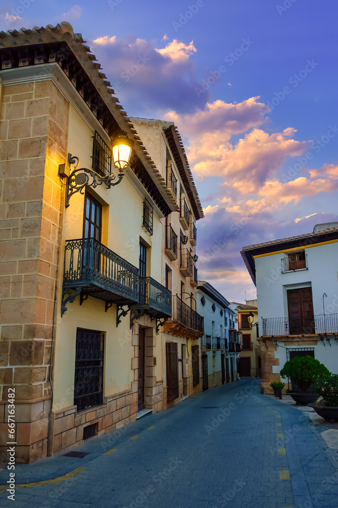 Quaint houses with lit street lamps in a white village of Almeria, Velez Rubio, Spain.