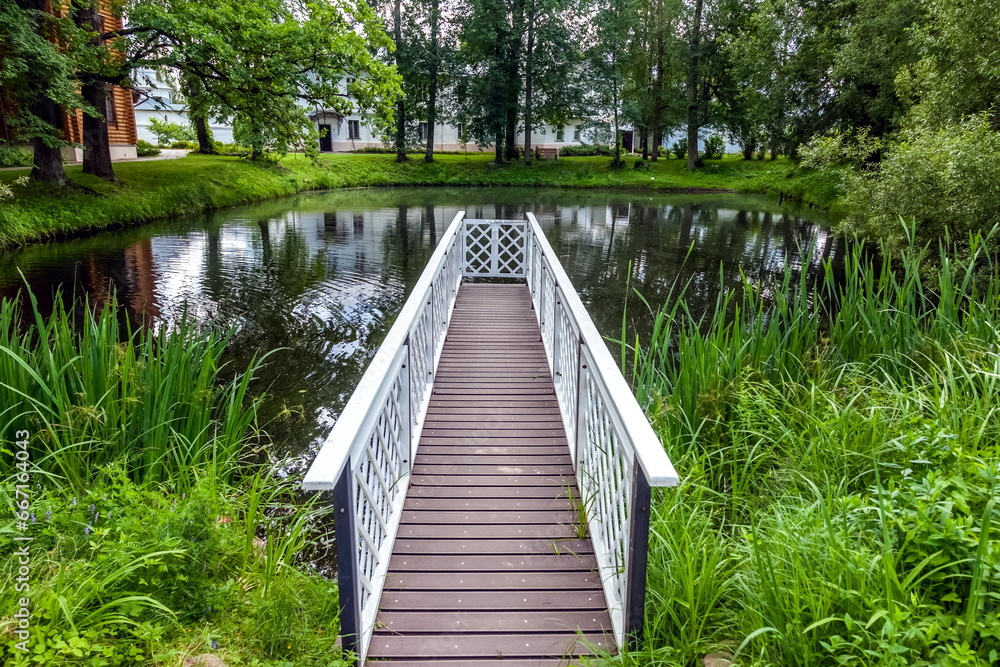 Wooden bridge on a small artificial lake in summer