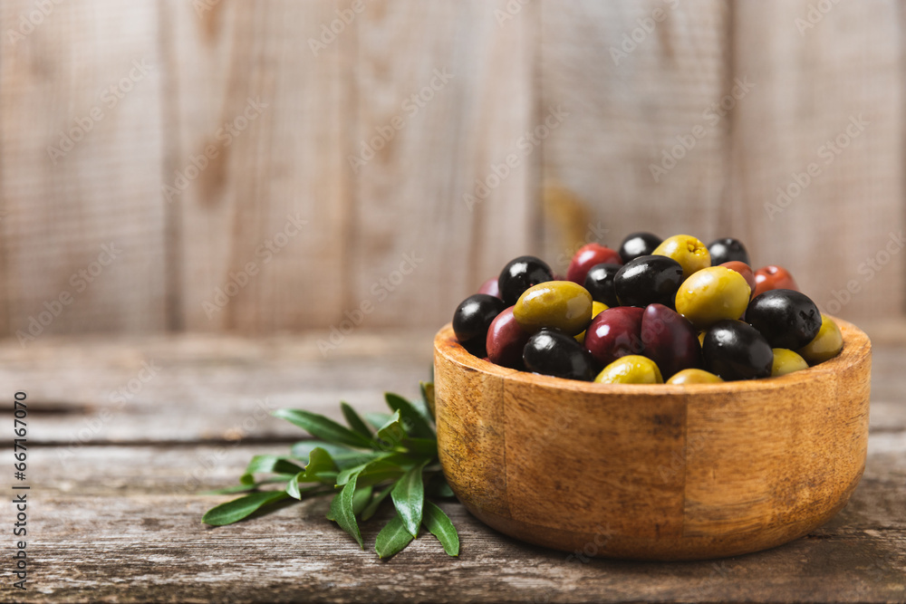 A set of green, red and black olives on background. Various types of olives in bowls and fresh olive leaves. Vegan. Olive fruits. Place for text. Copy space A set of green, red and black olives on background. Various types of olives in bowls and fresh olive leaves. Vegan. Olive fruits. Place for text. Copy space