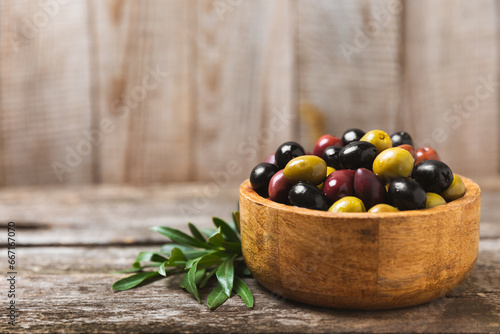Fototapeta Naklejka Na Ścianę i Meble -  A set of green, red and black olives on  background. Various types of olives in bowls and fresh olive leaves. Vegan. Olive fruits. Place for text. Copy space