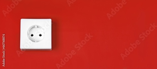 Minimalistic white power socket on red background.  Panoramic image with copy space.