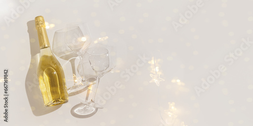Minimal style Top view sparkling wine and crystal wine glasses, bottle of champagne on shiny background, copy space. Festive alcoholic drink, party drink concept, beautiful shadows, star filter lights photo