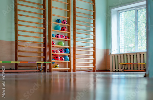 Empty sport gym with ladder for children climbing and benches on wooden floor in recreation playroom indoor
