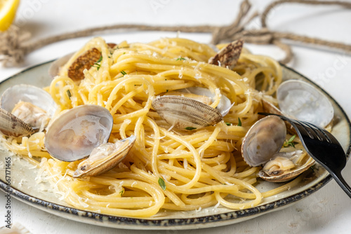 Pasta with shellfish in a plate, light background, close-up