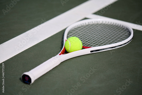 White tennis racket and ball on court