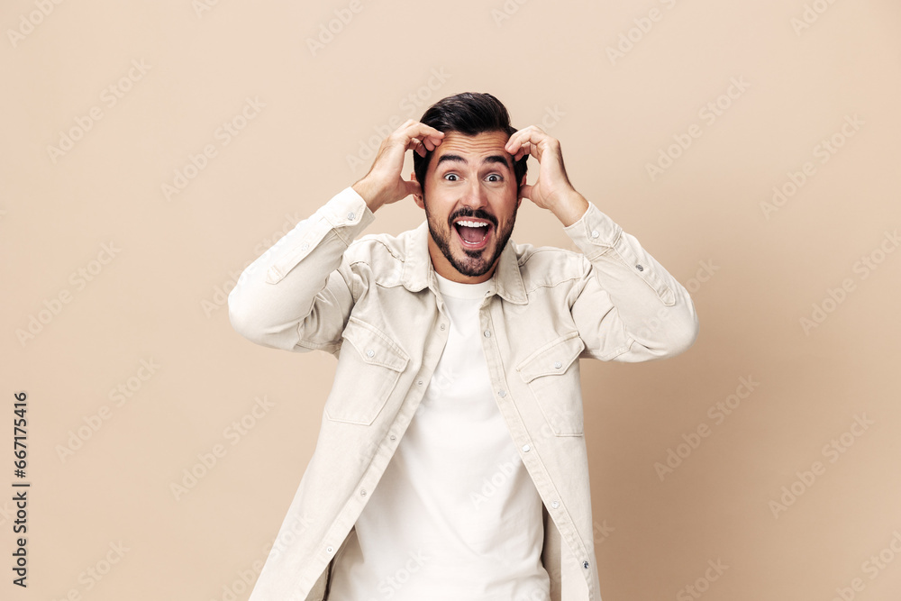 Portrait of a stylish man smile with teeth happiness opened his mouth in surprise on a beige background in a white t-shirt looks at the camera, fashionable clothing style, copy space, space for text Portrait of a stylish man smile with teeth happiness opened his mouth in surprise on a beige background in a white t-shirt looks at the camera, fashionable clothing style, copy space, space for text