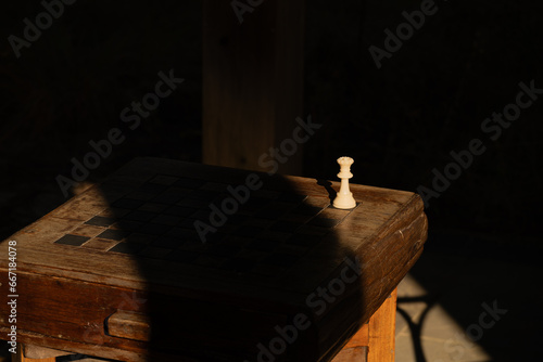 Queen chess piece on an outdoor board by itself