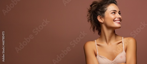 Happy woman displaying vaccinated arm on brown backdrop photo