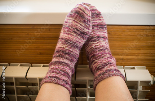 Feet in warm winter socks warm up on the radiator.