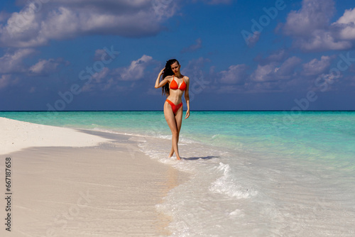 Young dreadlocks woman in bikini poses against sea background