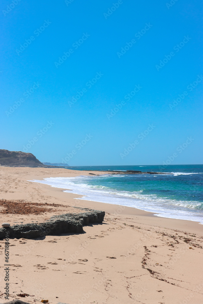 View over the Atlantic Ocean from shore. Portugal. Large beach with huge stone.