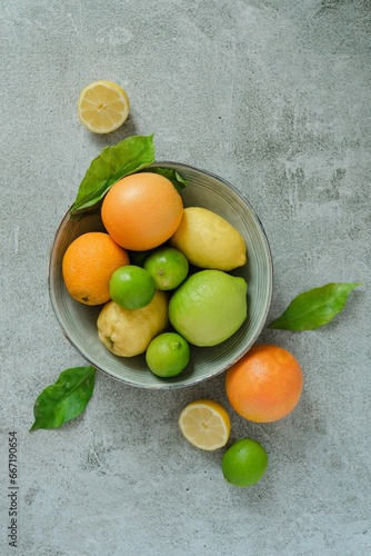 a bowl of fruit with lemons, limes and oranges