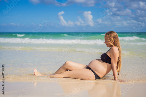Radiant pregnant woman in a swimsuit, amid the stunning backdrop of a turquoise sea. Serene beauty of maternity by the shore