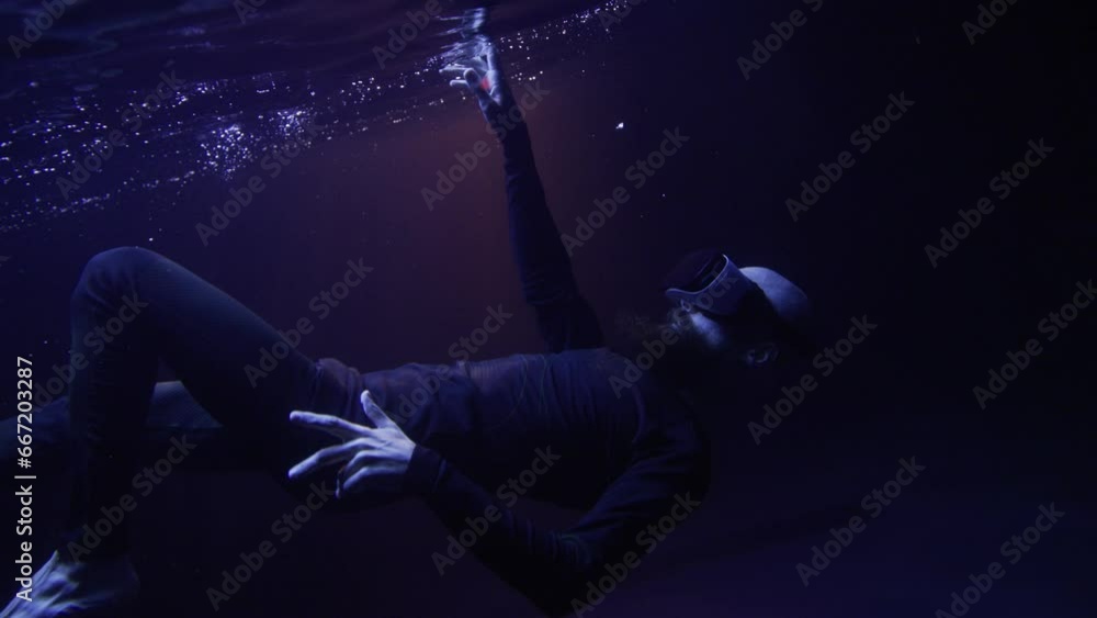 Man in futuristic costume under the water. Guy in glasses of virtual reality. Augmented reality game, future technology, AI concept. VR. Man in futuristic costume under the water. Guy in glasses of virtual reality. Augmented reality game, future technology, AI concept. VR.