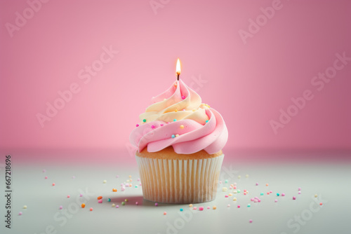 Birthday cupcake with candles on pastel colored background