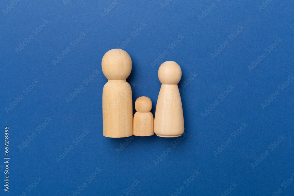 Wooden family figures on color background, top view Wooden family figures on color background, top view