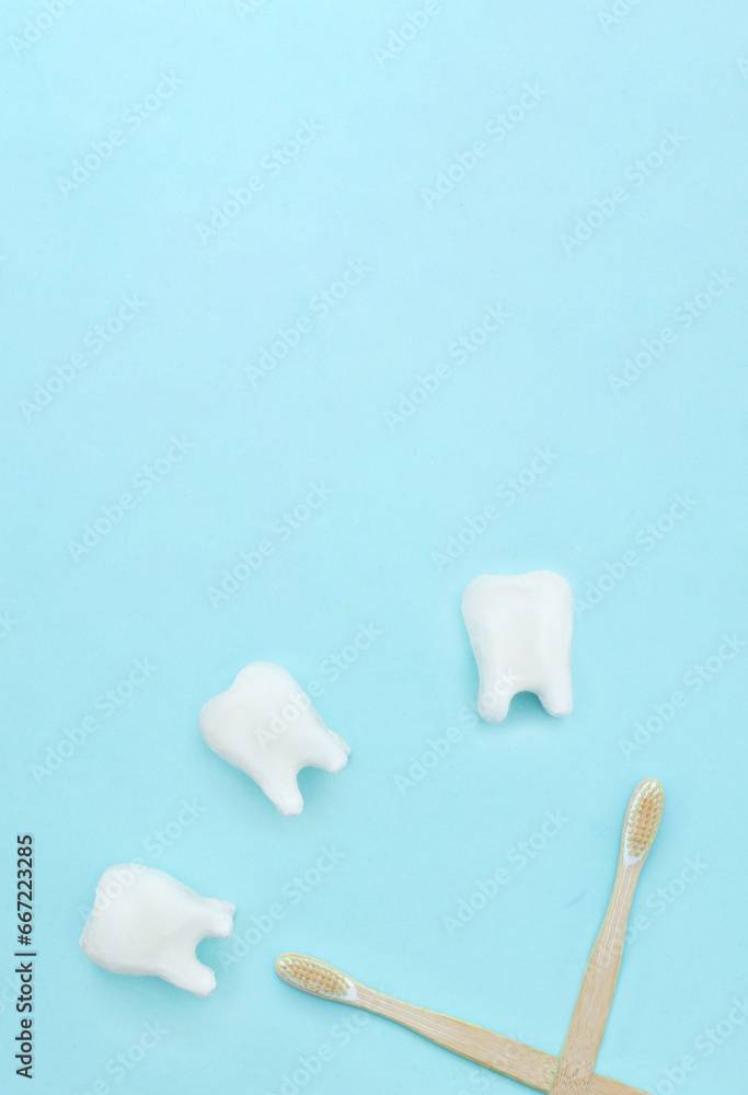 Care for oral and dental care concept. Regular checkups are essential to oral health. Flat lay, a clock made of tooth model on a blue background and a toothbrushes and copy space. Care for oral and dental care concept. Regular checkups are essential to oral health. Flat lay, a clock made of tooth model on a blue background and a toothbrushes and copy space.